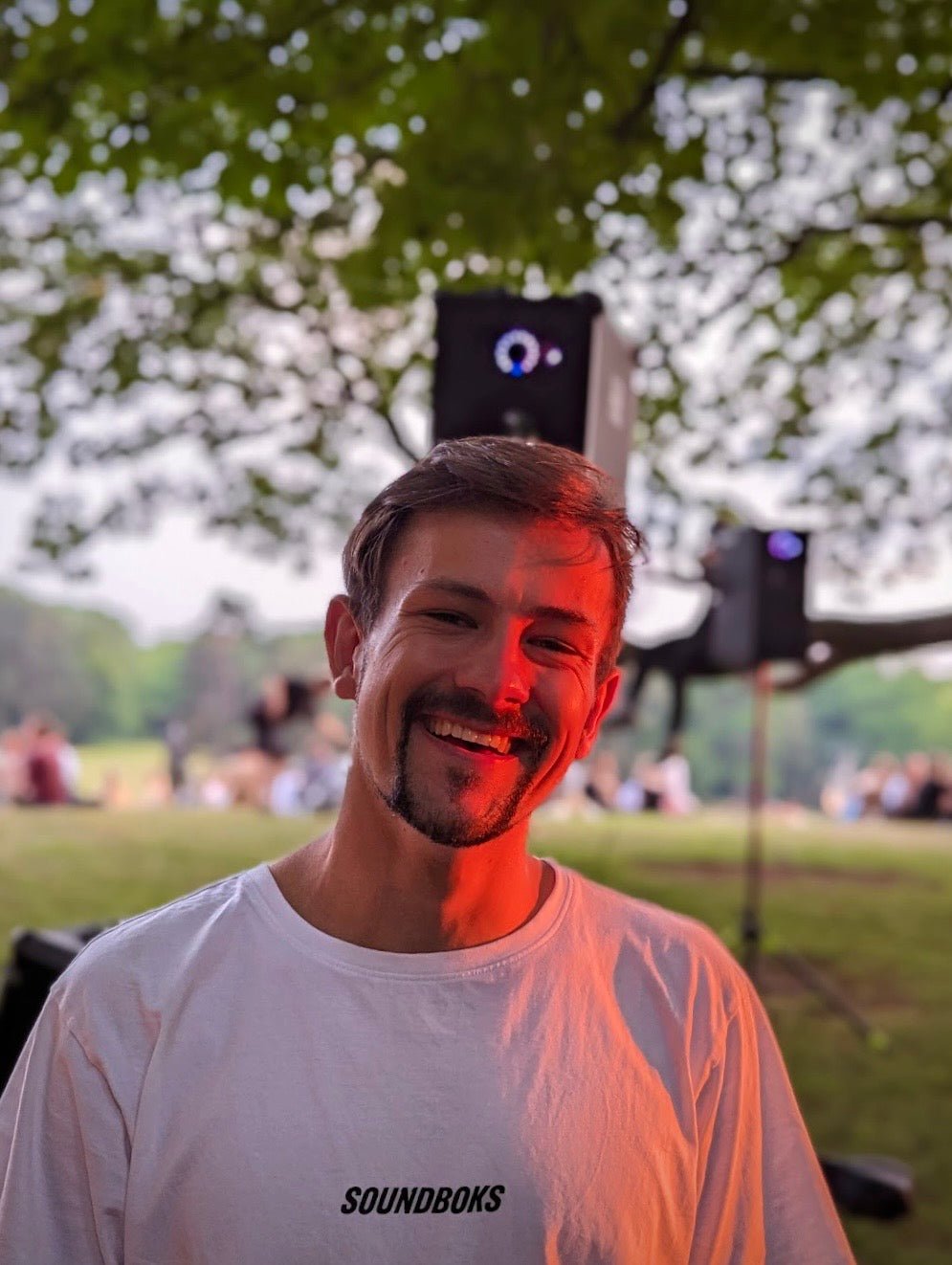 Jannis steht in einem Park vor einer Musikbox.