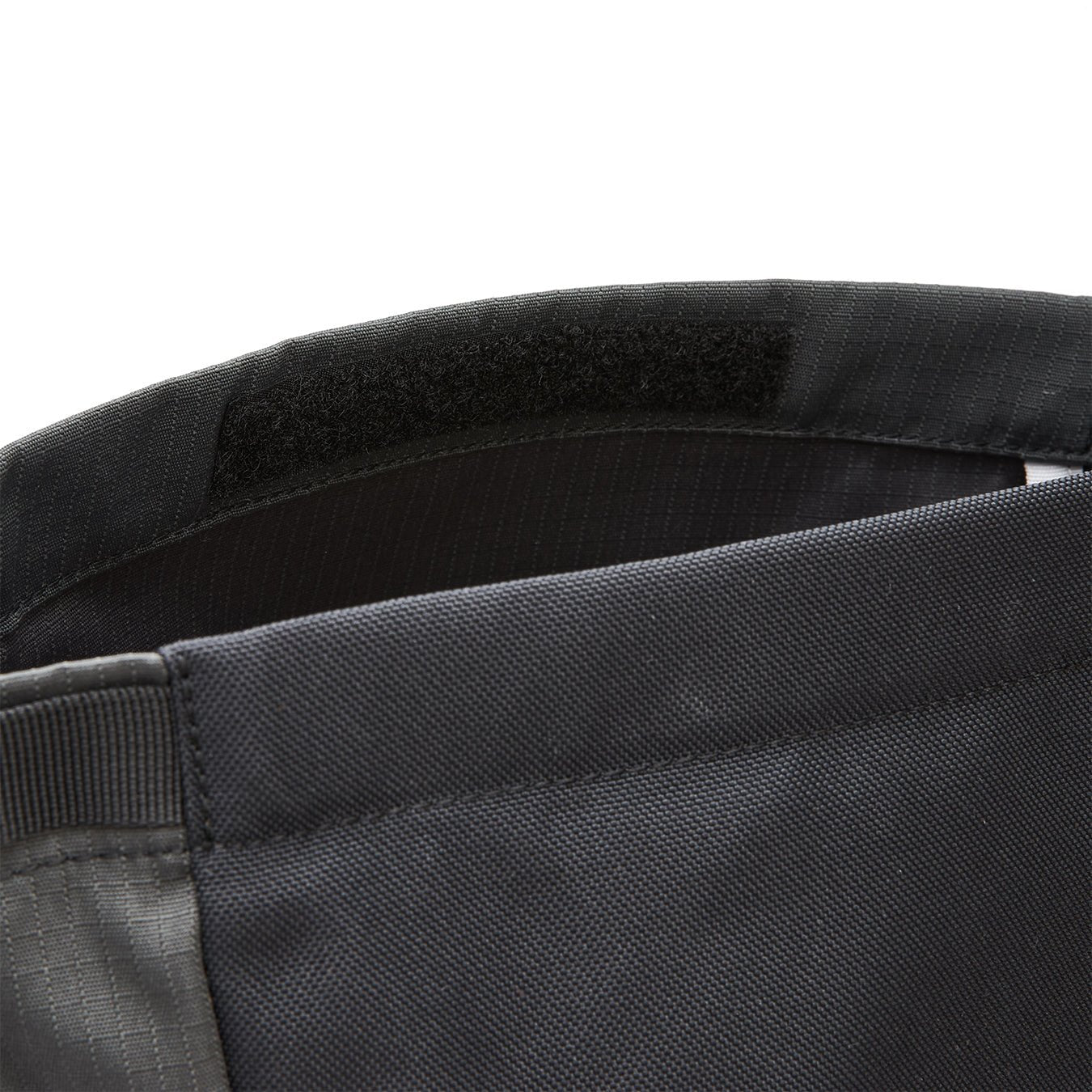 Ela Mo™ Rolltop Lite | Black. Klettverschluss an einem schwarzen Rucksack.