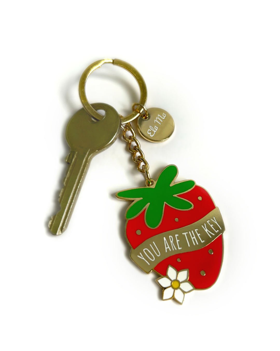 Ela Mo™ Schlüsselanhänger | Erdbeere. „Schlüsselanhänger in Form einer Erdbeere mit einem Schlüssel darauf.