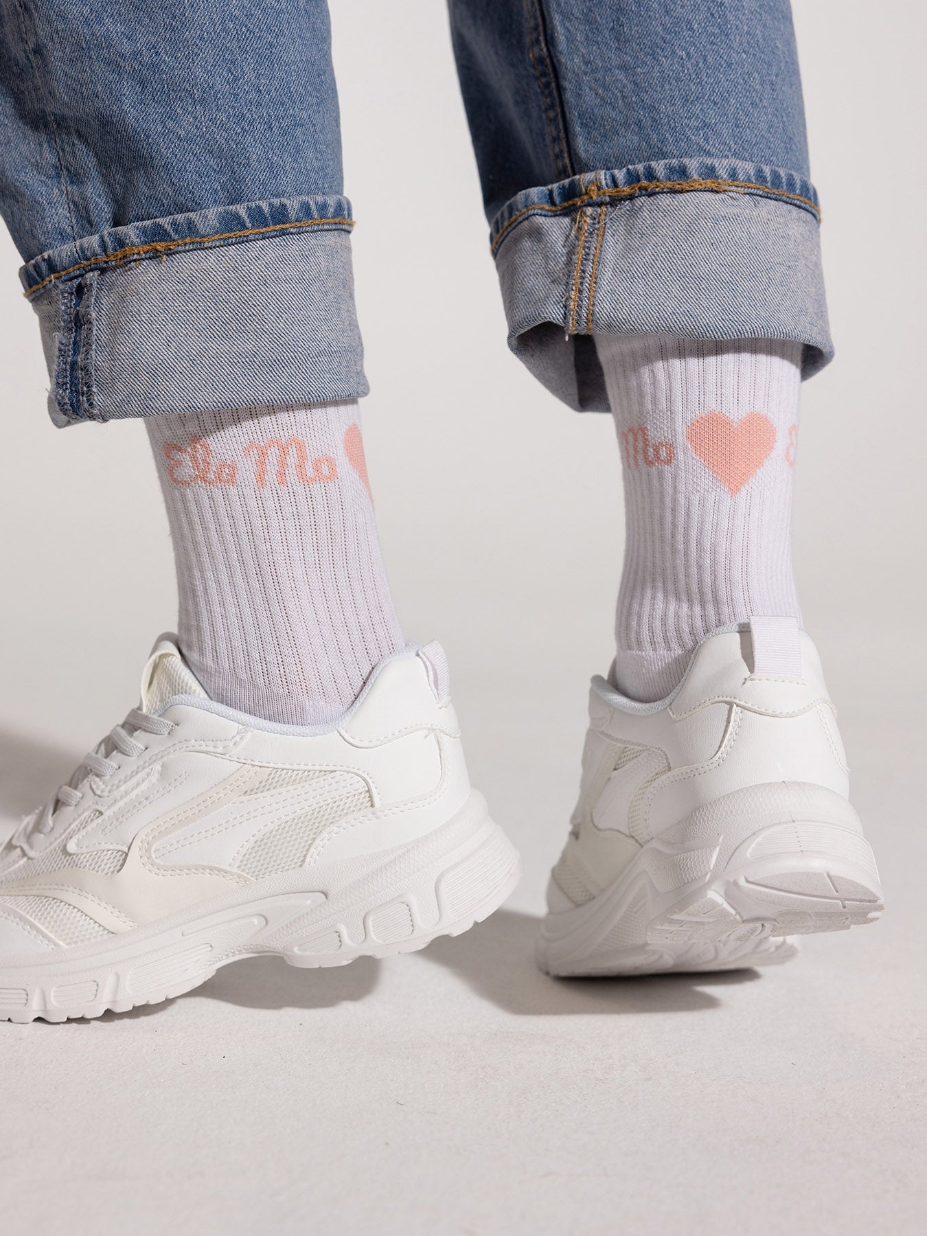 Ela Mo™ Socken aus Bio-Baumwolle-Eine Person in weißen Ema-Mo-Socken, Jeans und Sneakers – ein stylisches Alltagsoutfit.
