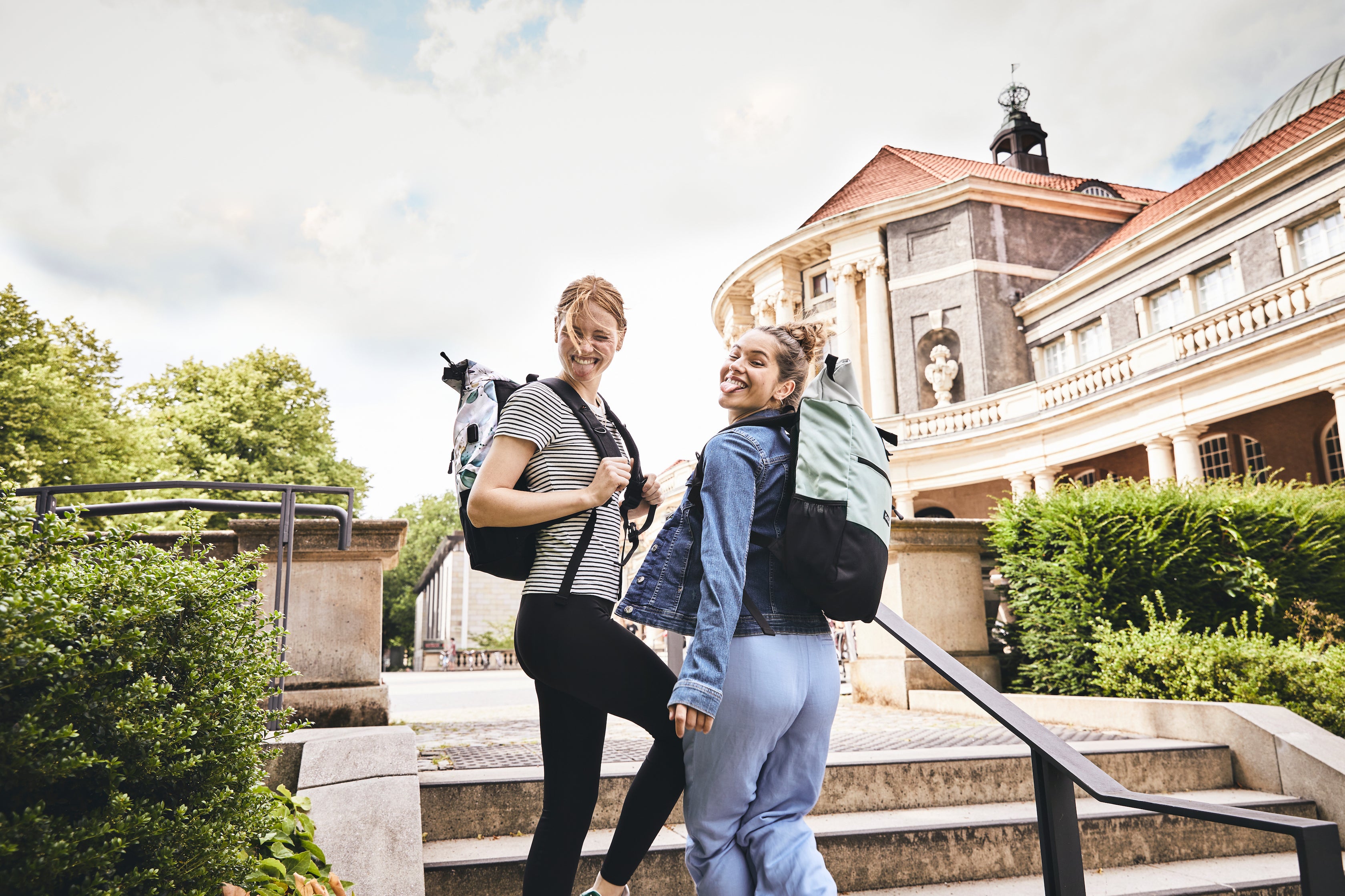 zwei Mädchen mit Schulrucksack auf Treppe
