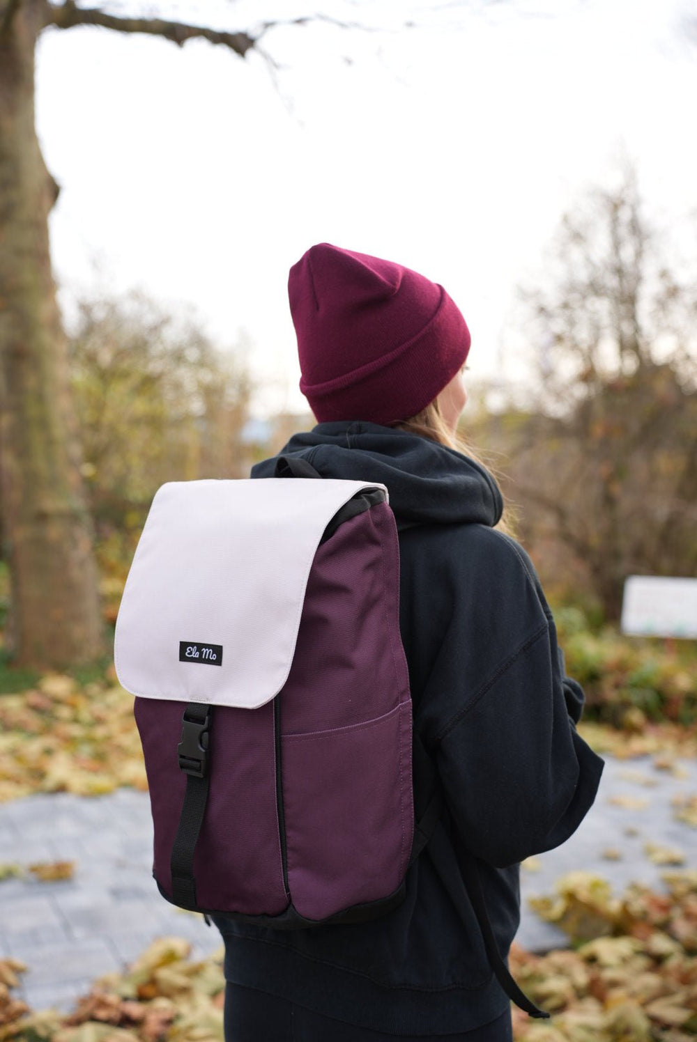 Ela Mo™ Everywhere Daypack | Grape. Eine Frau trägt den dunkellilafarbener Rucksack im Wald – ein Moment aus ihrem Alltag.