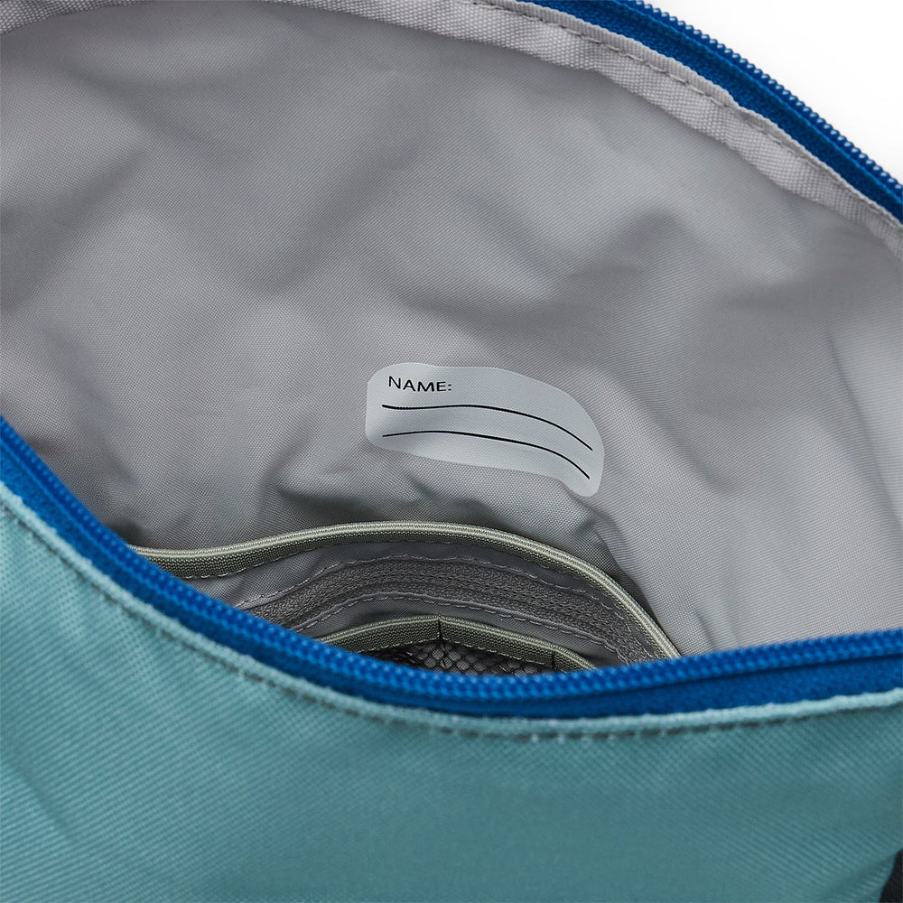 Ela Mo™ Kinderrucksack (6-10 Jahre) | Blue Mint. Der graue Innenbereich des Rucksacks mit einem Namensschild.
