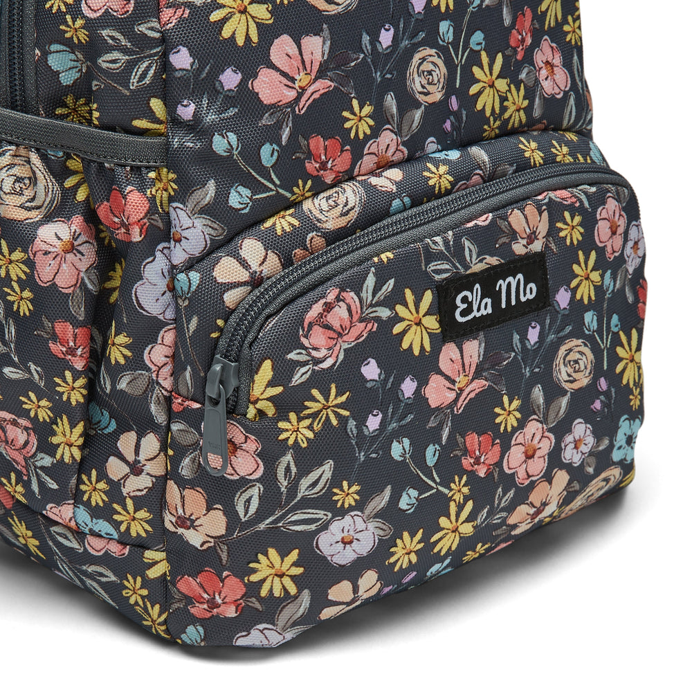 Ela Mo™ Mini Rucksack | Summer Meadows. Außenfach mit Herstellerlogo auf der Vorderseite des Rucksacks.