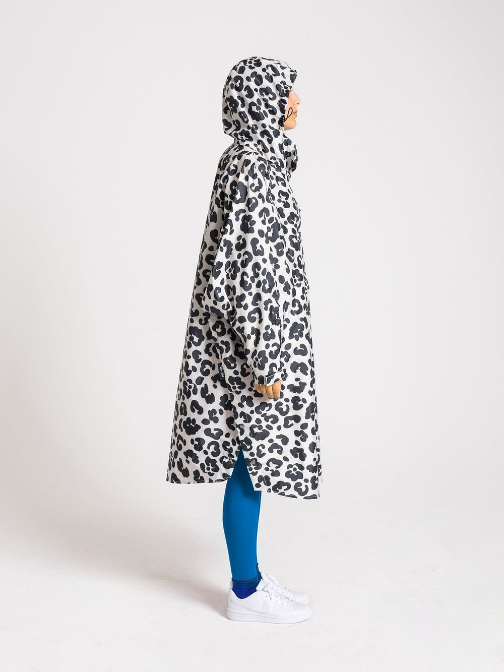 Ela Mo™ Regenponcho Leo von der Seite. Frau mit Regenponcho von der rechten Seite auf weißem Hintergrund.