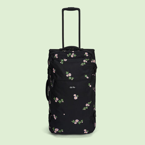 Ela Mo™ Reisetasche mit Rollen 78 Liter | Embroidery Edition Upsy Daisy. Schwarze, geblümte Tasche mit hochgezogenem Griff.