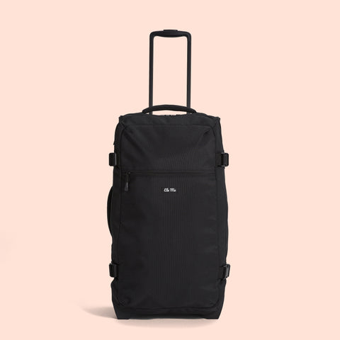 Ela Mo™ Reisetasche mit Rollen 78 Liter | Black. Eine Reisetasche mit hochgezogenem Griff und Außenfach mit Reißverschluss.