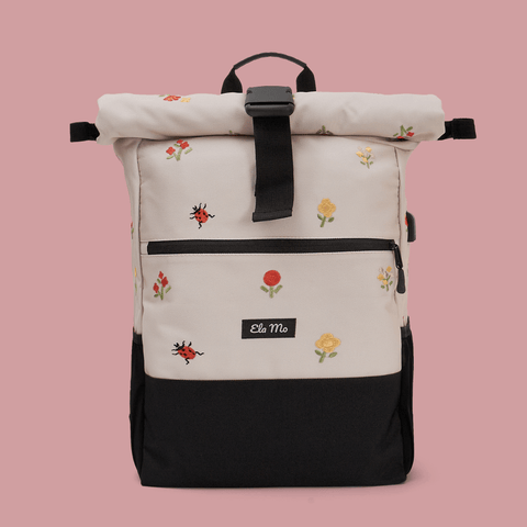 Ela Mo™ Rolltop Rucksack | Embroidery Edition Losy. Ein Rucksack auf rosa Hintergrund mit Herstellerlogo in der Mitte.